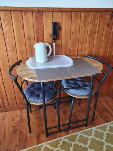 a table with two chairs and a cup on it at Pokoje Gościnne Angelika in Wisła