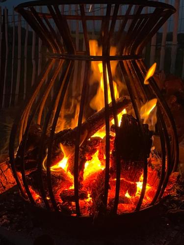 un fuego arde en un foso de fuego por la noche en La Souricière, en Silenrieux