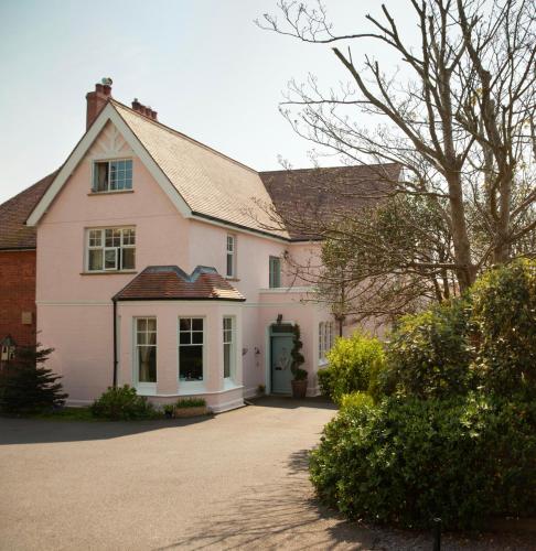 a white house with a green door on a driveway at St Katharine's House in Milford Haven