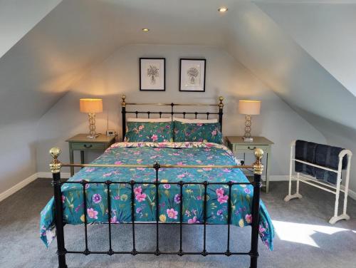 鄧弗姆林的住宿－NEW Fabulous 2BD Maisonette Dunfermline, Fife，一间卧室配有一张床、两张桌子和两盏灯。