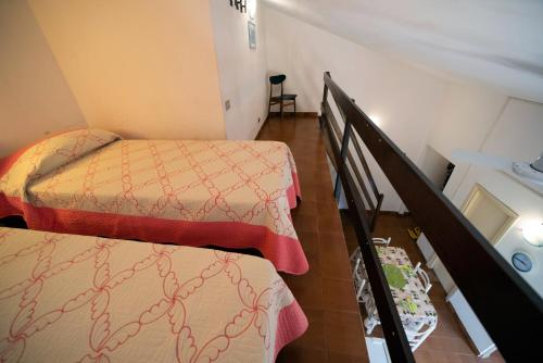 a small room with two beds and a staircase at Appartamento Laura in Porto Azzurro