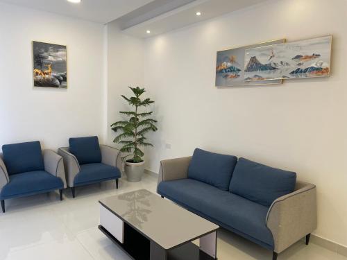 a living room with two blue couches and a table at Season Inn Hotel Apartment_Duqm in Duqm