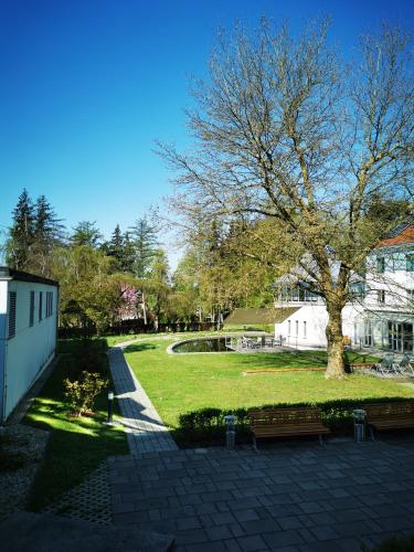 a park with benches and a tree and a building at Spectrum Kirche Exerzitien-und Bildungshaus auf Mariahilf in Passau