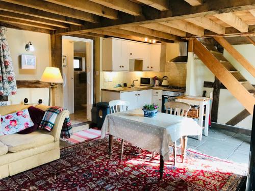 uma sala de estar com uma mesa e uma cozinha em The Cottage, Winley Farm em Bromyard