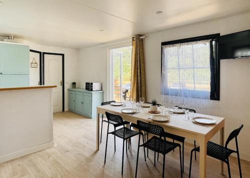 Cette chambre comprend une cuisine et une table avec des chaises. dans l'établissement Charmant Chalet avec terrasse et accès piscine., à Rocbaron