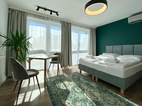 um quarto com uma cama, uma mesa e cadeiras em InvestRooms em Gdansk