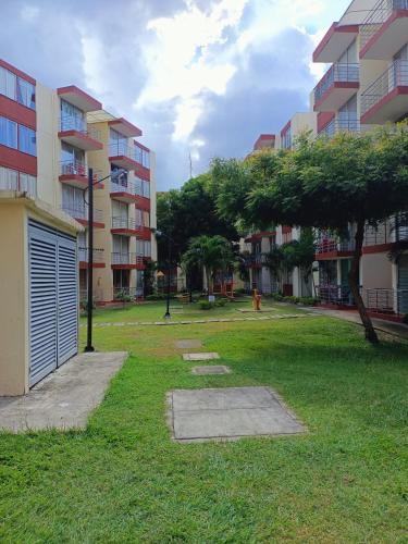 a park in front of a building with a garage at Apartamento vacacional en Flandes tolima in Flandes