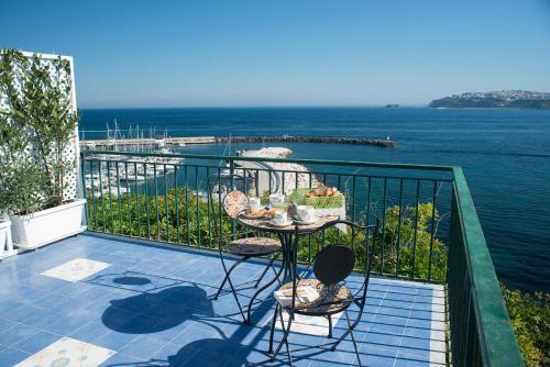 una mesa en un balcón con vistas al océano en Punta Lingua Relais- Room 1 Sunrise Terrace, en Procida