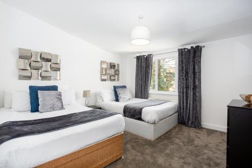 a bedroom with two beds and a window at Preston Mews by Sorted Stay - 3 Bed House with a Hot Tub & Free Parking in Southend-on-Sea