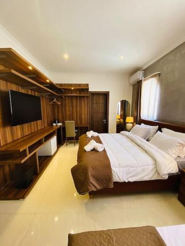 a bedroom with a large bed and a flat screen tv at Velver Mansion, Malta - Luxury Villa with Pool in Naxxar