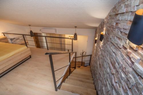 a staircase in a room with a brick wall at La Costa Apartments in Bar