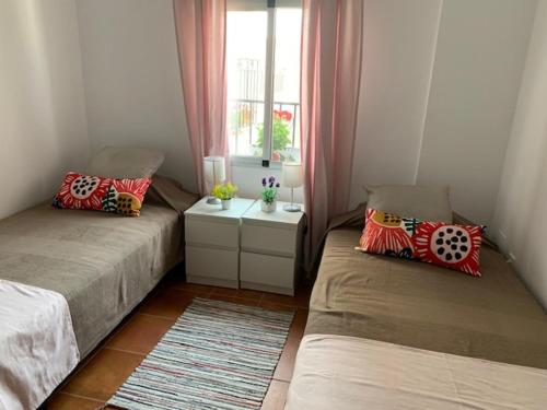 two beds in a small room with a window at La Casa de Sally- Vèlez Blanco in Vélez Blanco