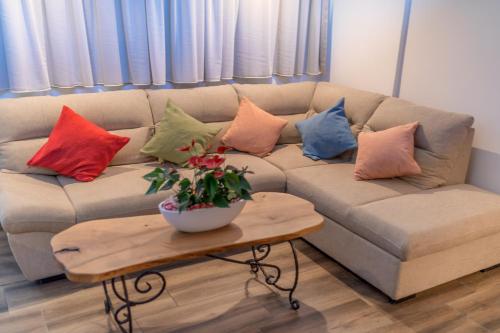 a couch with colorful pillows on it in a living room at La Costa Apartments in Bar