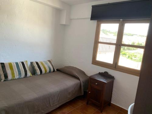 a small bedroom with a bed and a window at La Casa de Sally- Vèlez Blanco in Vélez Blanco