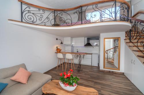 a living room with a couch and a spiral staircase at La Costa Apartments in Bar