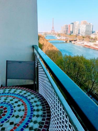 a balcony of a building with a view of a river at EIFFEL TOWER PENTHOUSE in Paris