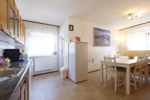a kitchen with a table and a white refrigerator at Apartments and Rooms Banić in Kranjska Gora