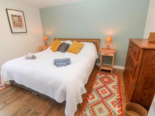 a bedroom with a large white bed with yellow pillows at Widgeons Keel in Falmouth