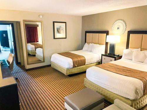 a hotel room with two beds and a mirror at Eleven Boutique Hotel LLC in Emporia