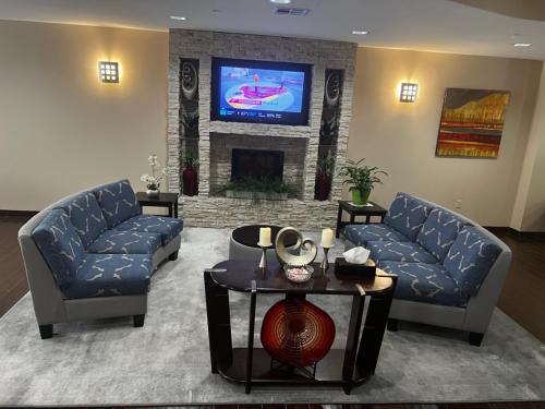 a living room with two blue couches and a tv at Comfort Suites Mandeville - Covington in Mandeville