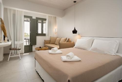 a bedroom with a large bed with towels on it at Melidron Hotel & Suites in Agios Prokopios