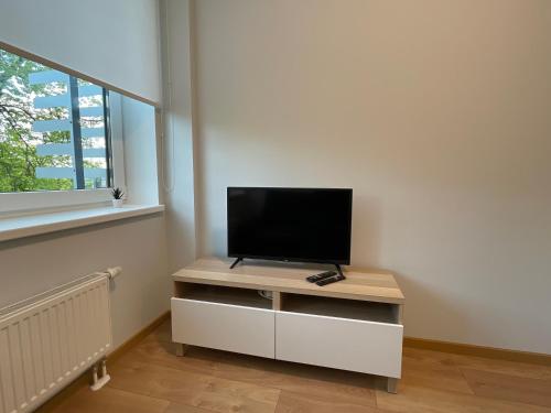 a flat screen tv sitting on top of a white cabinet at Pepleri Studio 49 in Tartu