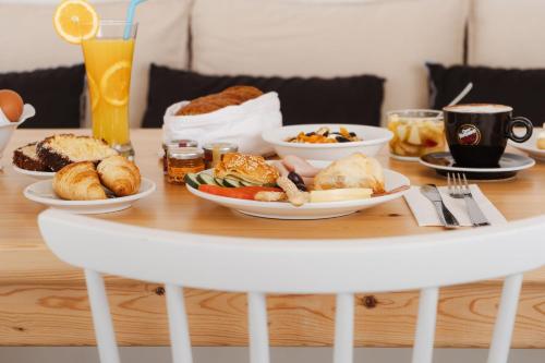 a table with plates of breakfast foods on it at Melidron Hotel & Suites in Agios Prokopios