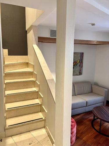 a staircase in a living room with a couch at NH Collection Salamanca Palacio de Castellanos in Salamanca