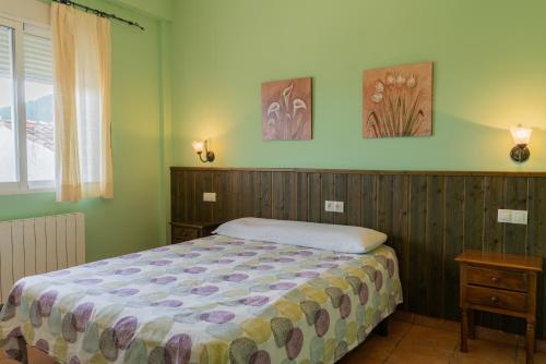 a bedroom with a bed and two pictures on the wall at Apartamentos rurales Casas de Haches in Las Casas de Haches