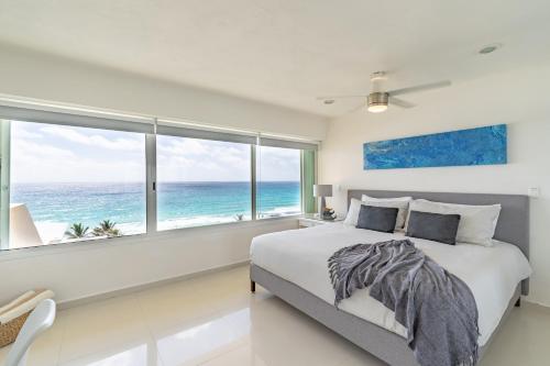 um quarto com uma cama e vista para o oceano em Ocean View Three Bedroom, Three Story Penthouse by the Beach em Cancún