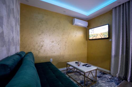 a living room with a green couch and a table at Foča Apartmani "Story Lux" in Foča
