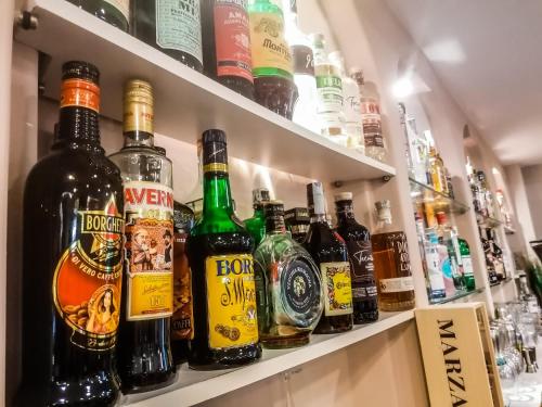 a shelf filled with lots of bottles of alcohol at Hotel A Casa Nostra in Rimini
