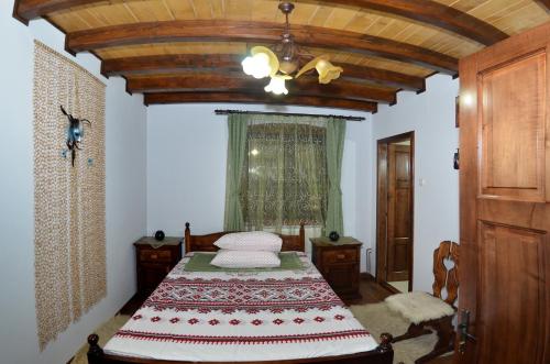 a bedroom with a bed and a ceiling fan at Cabana Paradisul Verde Neamt in Tîrgu Neamţ