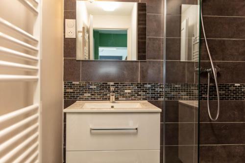 een badkamer met een wastafel en een spiegel bij LA MAISONNETTE in Thueyts