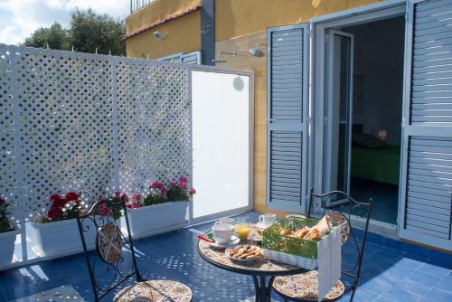 a table with a basket of food on a patio at Punta Lingua Relais - Room 2 Sunset Terrace in Procida