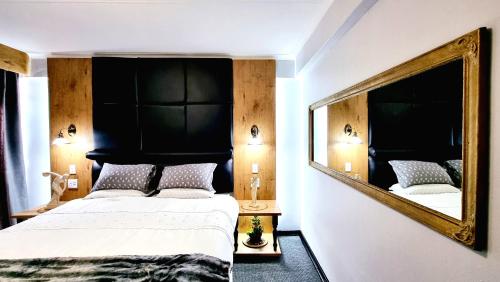 een slaapkamer met een grote spiegel en een bed bij Affordable Hyswan Family Guesthouse in Krugersdorp