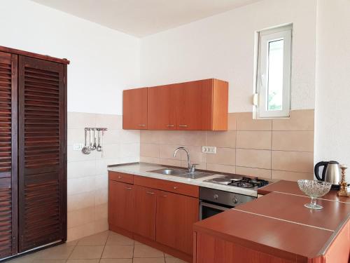 a kitchen with wooden cabinets and a sink at Villa Brela in Brela