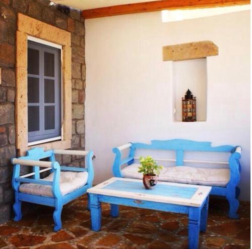 Habitación con 2 sillas azules y mesa. en Apanemo en Grikos