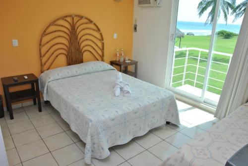 1 Schlafzimmer mit 2 Betten und einem großen Fenster in der Unterkunft Hotel Boca de Ovejas in El Morro
