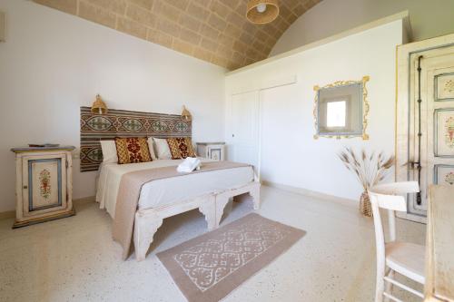 una camera con letto, sedia e specchio di Tenuta Puloni a Otranto