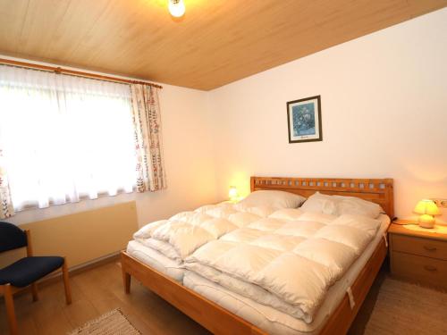 Un dormitorio con una cama grande y una ventana en Apartment Heidi, en Vandans