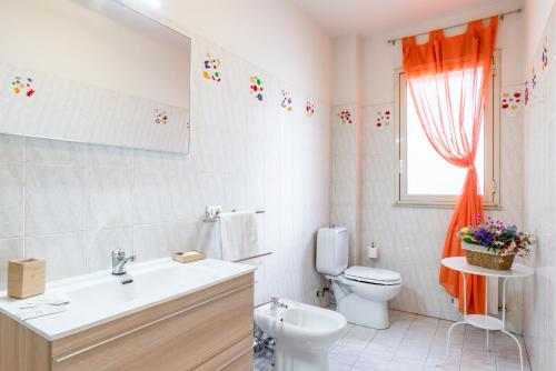 a bathroom with a toilet and a sink and a window at Castello Normanno Modern Sea View Apartment in Aci Castello