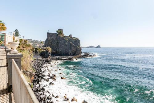a view of the ocean and a rocky beach at Castello Normanno Modern Sea View Apartment in Aci Castello