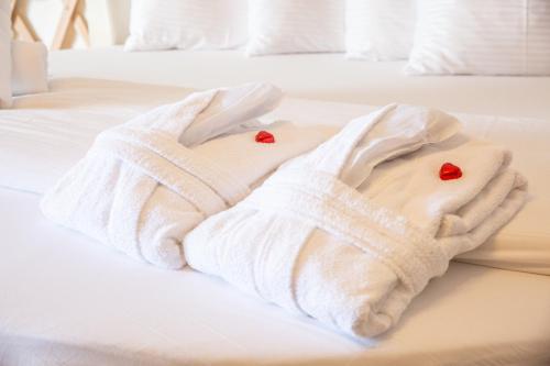 a white towel on a bed with hearts on it at Sea Zen Resort in Ma'ale Gamla