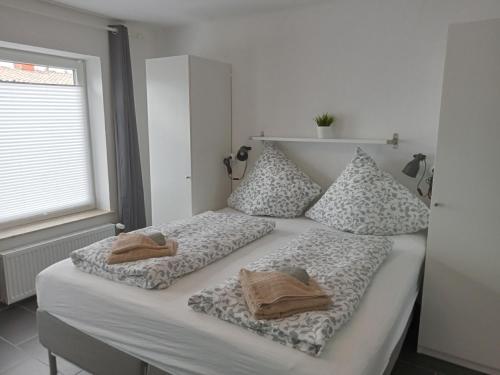 Una cama con dos toallas encima. en Ferienhaus am Binnenhafen, en Emden