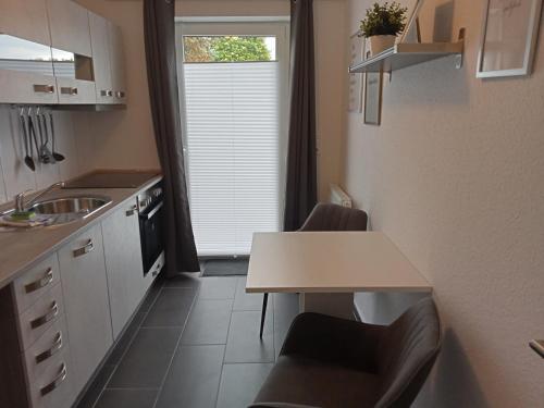 a kitchen with a table and chairs and a window at Ferienhaus am Binnenhafen in Emden