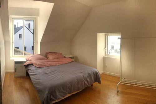 1 dormitorio con 1 cama y 2 ventanas en Longère location saisonnière en Le Hézo