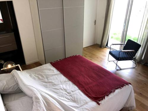Un dormitorio con una cama con una manta roja. en Longère location saisonnière en Le Hézo