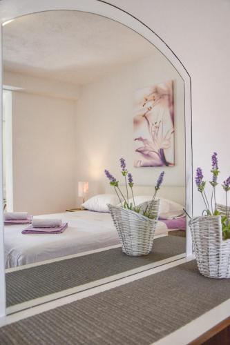 a mirror in a bedroom with purple flowers on a bed at Apartments Sena in Bol