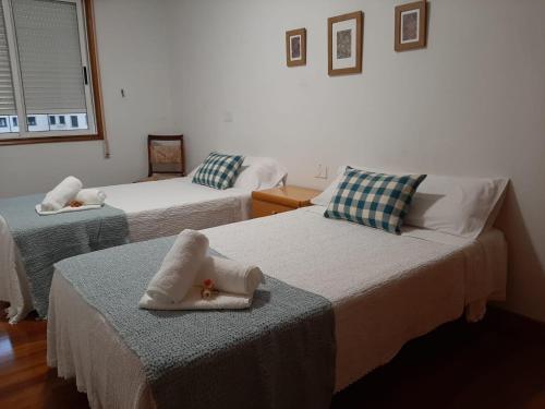 a room with two beds with towels on them at Pensión A Fonte in Caldas de Reis